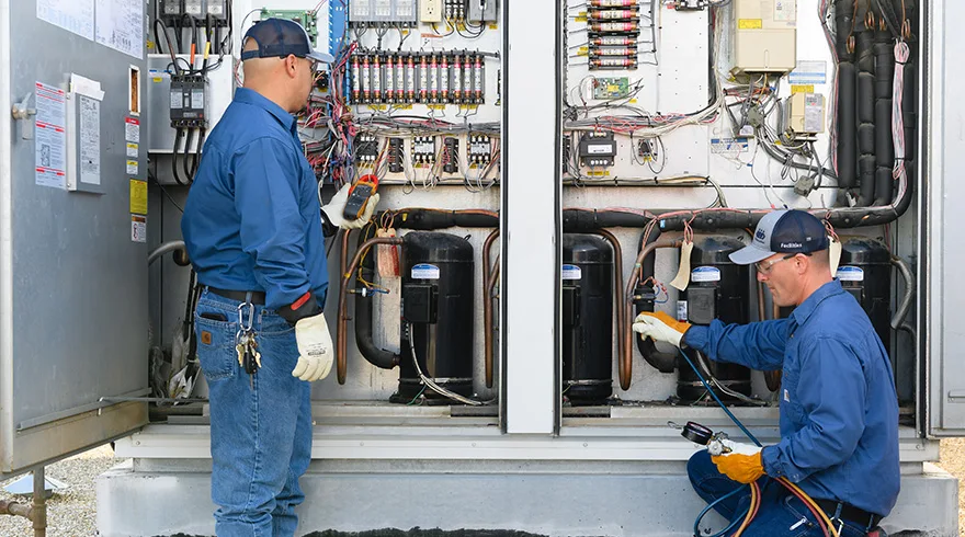 Air conditioning condenser unit being serviced outside a Philadelphia row home